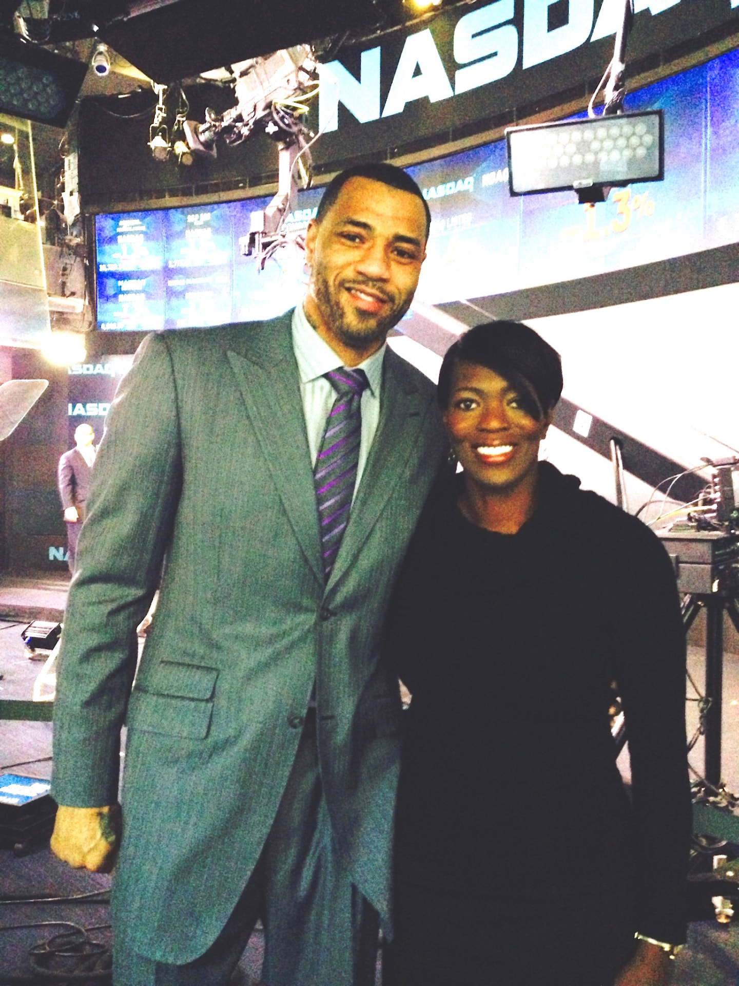 Tina J. Wheeler standing with NBA veteran Kenyon Martin inside the NASDAQ MarketSite studio.