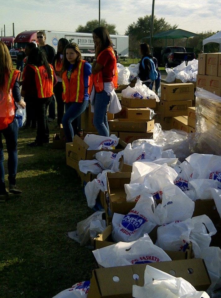 Volunteers organizing food packages and supplies during an NBA Cares community-distribution initiative.