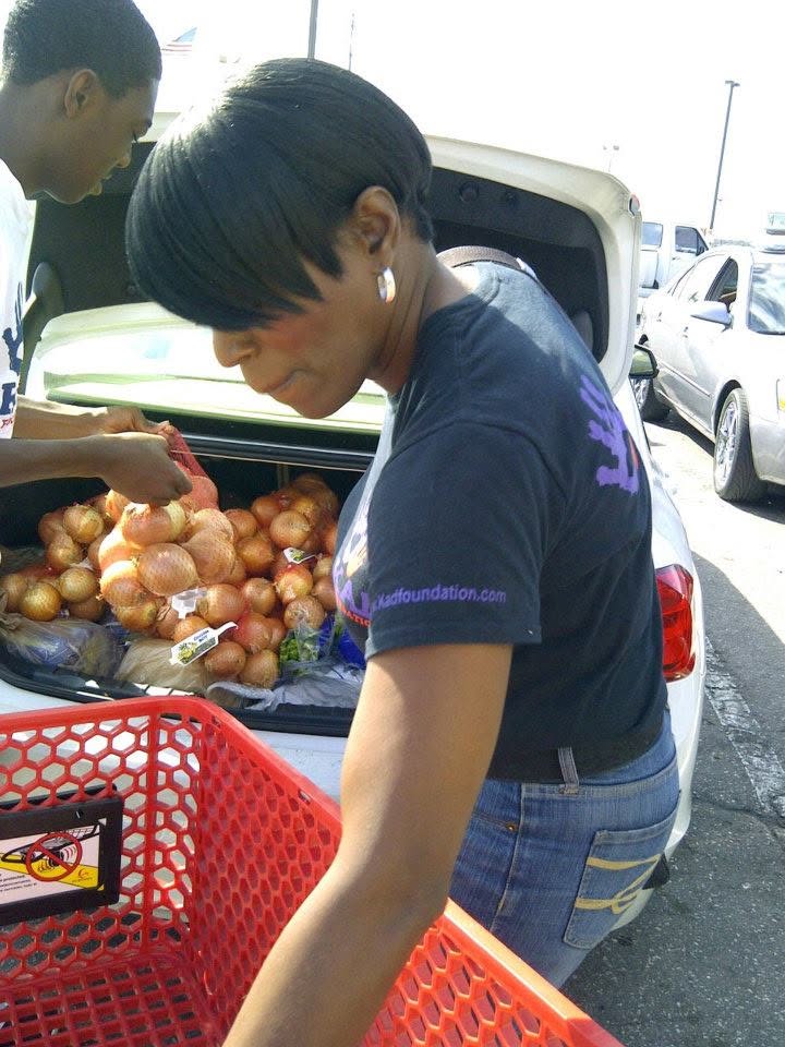 Tina J. Wheeler loading food during a KAD Foundation community-service initiative.